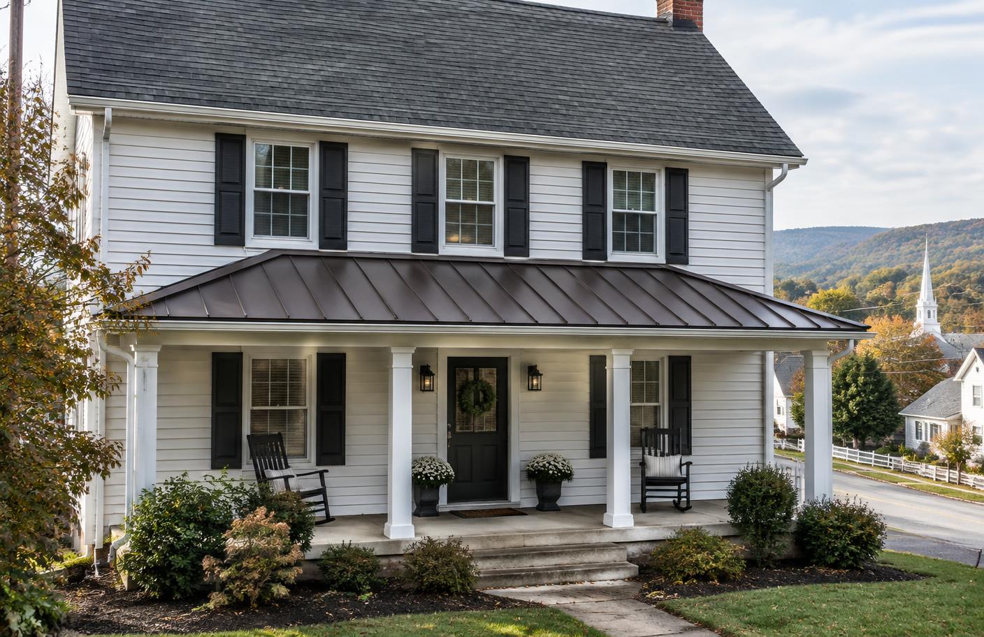 Standing seam metal porch roof below an asphalt shingle main roof