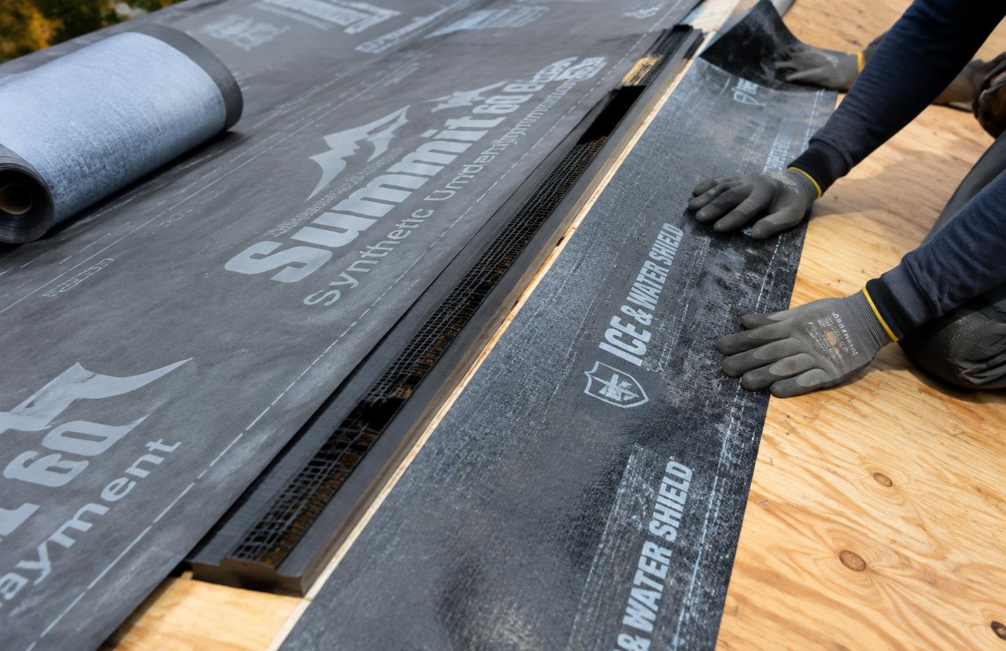 Ice barrier and underlayment going on new roof decking near a ridge vent